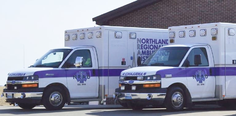 two northland regional ambulance district ambulances parking in front of a house