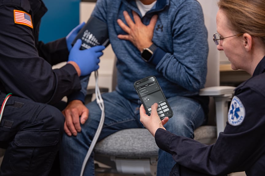 EMT using an app to chart on scene with a patient