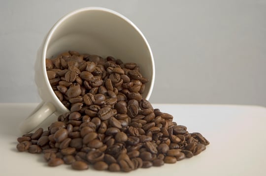 Coffee cup with coffee beans galore