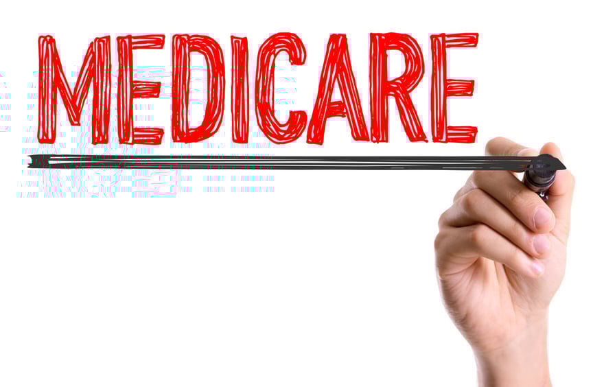 Hand with marker writing the word Medicare