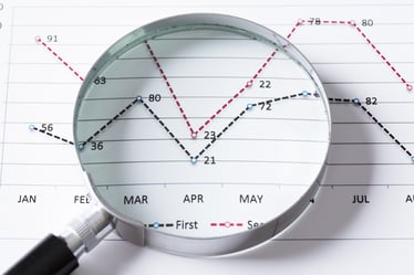 Magnifing glass and documents with analytics data lying on table-1