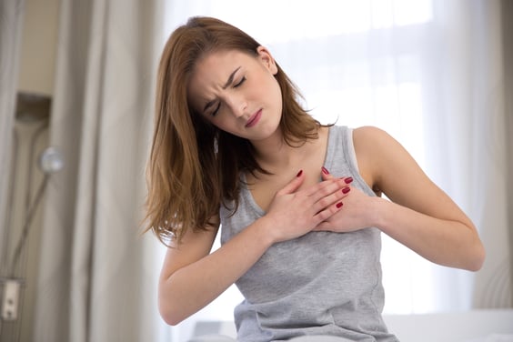 Young woman in pajamas having trouble breathing