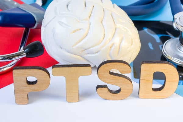 PTSD wooden letters in front of brain model