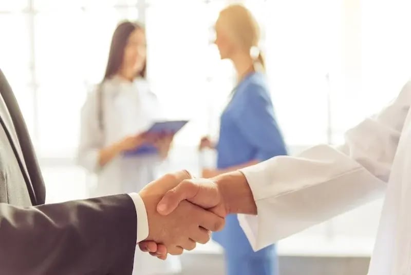 Doctor and business professional shaking hands